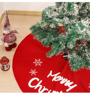 Red knit Christmas tree skirt with white snowflake patterns and Merry Christmas text