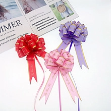 Close-up of red, pink, and purple pull bows with gold edges and Just for you text
