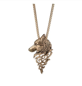 Vue détaillée d'un pendentif tête de loup doré vintage avec motif tribal sur fond blanc