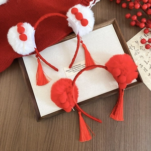 Detailed view of red plush pompom headbands with silk tassels for Lunar New Year decor