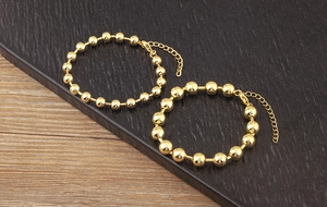Close-up of 18k gold plated bead bracelets with adjustable lobster clasp and chain
