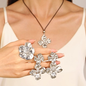 Vue détaillée d'un ensemble de bijoux fleurs en argent avec bague et boucles