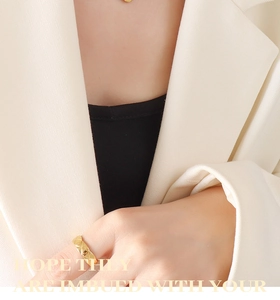 Detail of gold quilted ring with geometric pattern and matching circular pendant necklace
