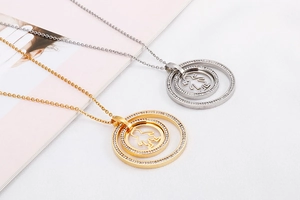 Close-up of gold and silver necklaces with crystal-encrusted circles and cut-out figures
