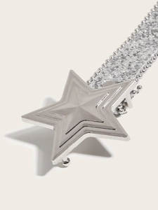 Detail showing a silver star-shaped metal buckle with glittering sequins on a modern belt