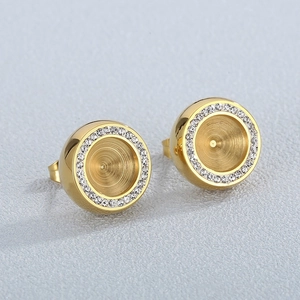 Minimalistische goldene Zirkonia-Ohrstecker mit Kristallkranz auf grauem Hintergrund