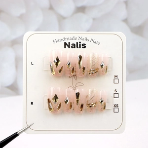 Detail of pink press-on nails with dragon scale glitter and rhinestone accents