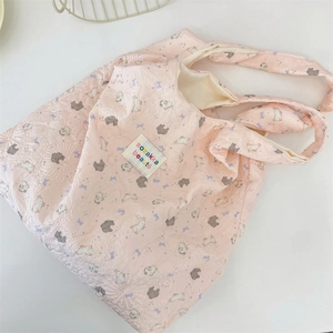Detailed close-up of pink quilted shoulder bag with embossed rabbit pattern and soft texture