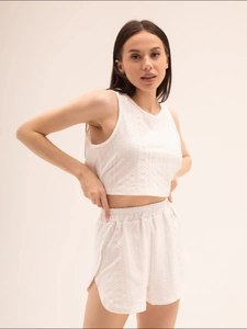 Détail de la délicate broderie anglaise blanche sur un ensemble pyjama sans manches