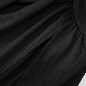Détail macro du tissu noir présentant une texture plissée et une couture double ligne