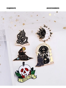Close-up of five gothic enamel pins featuring mystic moon and magic skull designs