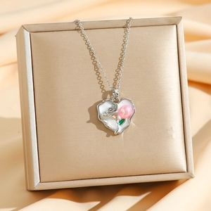 Close-up of heart tulip pendant necklace displayed on a champagne silk jewelry box