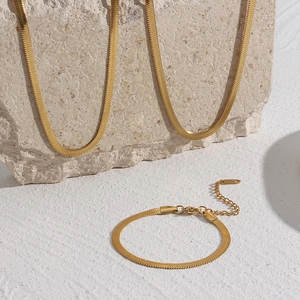 Detail of 18K gold plated flat snake chain set featuring necklaces and bracelet