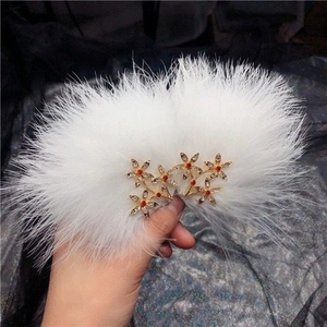 Fermaglio per capelli con piume bianche, fiore in metallo dorato e strass rosso