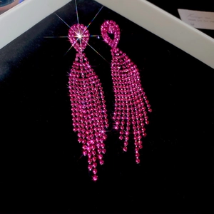 Detailed close-up of pink rhinestone heart stud earrings with long tassel fringe design