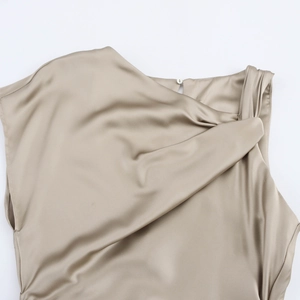 Detail van de satijnen jurk in champagne met geknoopte schouder en knoopsluiting achter