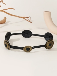 Detail of vintage black PU leather belt featuring antique brass hollow rings and studs
