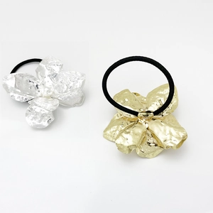 Detail of vintage flower hair ties in gold and silver with pearl accent and elastic band
