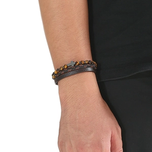 Macro detail of men's leather multi-layer bracelet with tiger eye beads and cross charm