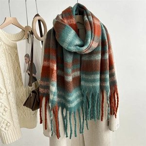 Detail of soft mohair striped scarf in orange and teal with decorative fringe tassels