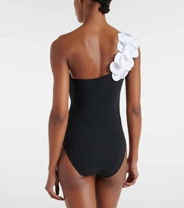 Rear view of one-shoulder black swimsuit featuring a 3D white floral petal detail