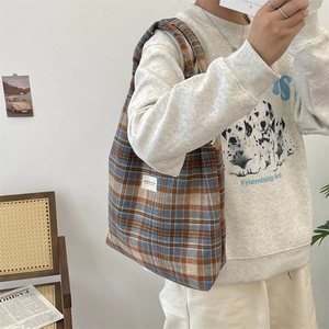 Detail of vintage plaid tote bag with classic check pattern and white woven brand label
