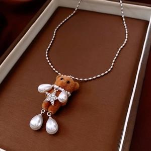 Detail of flocked bear pendant with silver star zircon and drop pearl in a gift box