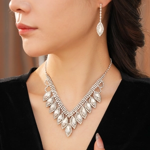Close-up of elegant V-shaped rhinestone necklace and drop earrings on a model