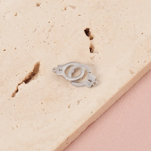 Macro shot of silver stainless steel handcuff pendants on a natural stone background