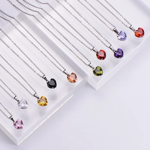 Multiple faceted crystal heart necklaces in various colors with silver metal chains