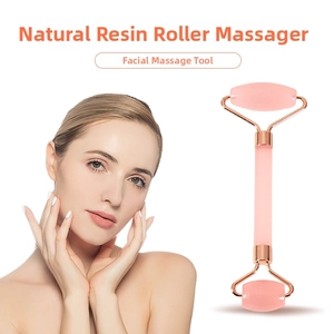 Nahaufnahme des doppelköpfigen rosa Harz-Gesichtsrollers mit roségoldenem Metallrahmen