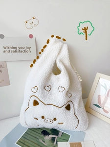 Close-up of white plush handbag with cute pig embroidery and soft lamb wool texture
