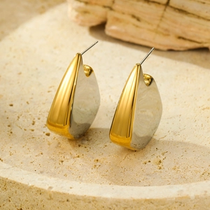 Polished gold and silver two-tone irregular fin-shaped stud earrings on stone