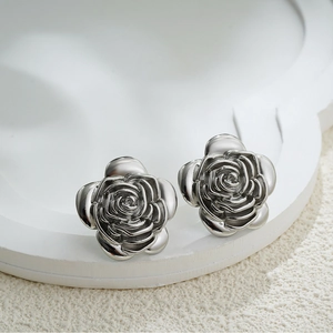 Elegant silver 18K gold rose flower stud earrings on white tray for women