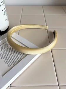 Detail of pale yellow satin sponge headband on a minimalist elegant prop display