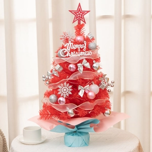 Close-up of red mini desktop Christmas tree with pink ornaments and star topper