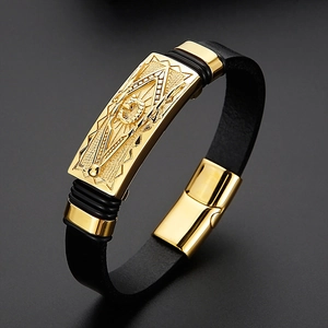 Détail d'un bracelet en cuir tressé noir pour homme avec breloque gravée dorée