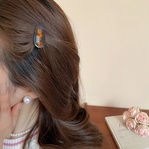 Barrette à cheveux écaille de tortue et bijoux en perles sur cheveux bruns ondulés