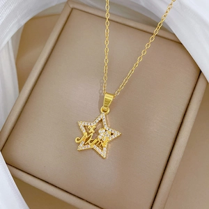 Gold star necklace with Mama engraving and pavé crystals on a soft fabric display