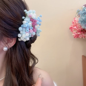 Detail showing colorful acrylic flower hair clips worn by model for an elegant hairstyle