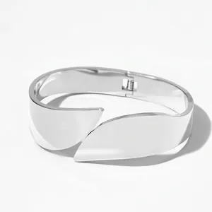 Macro shot of wide polished stainless steel bangle featuring overlapping petal design