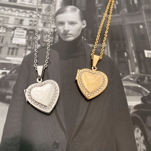 Detail of heart-shaped locket pendants with shimmering crystal edges on thin chains