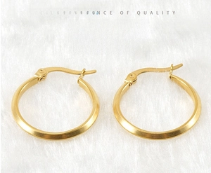 Close-up of gold stainless steel hoop earrings with triangular geometric facets