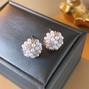 Macro detail of elegant pearl cluster earrings with zircon stones on black jewelry box
