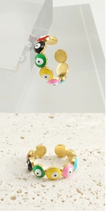 Detail view of colorful enamel evil eye rings on glass and stone bases in gold finish