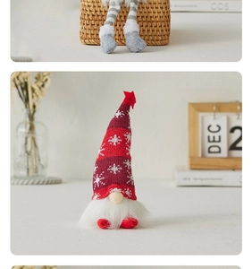 Detailed view of a red knitted Christmas gnome with snowflake patterns and star on top