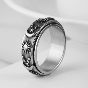 Macro shot of celestial spinner ring with engraved sun, moon and star patterns