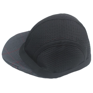 Macro shot of breathable black mesh fabric and grey plaid brim on a newsboy cap