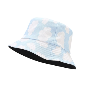 Reversible bucket hat with blue sky white cloud pattern and solid black lining