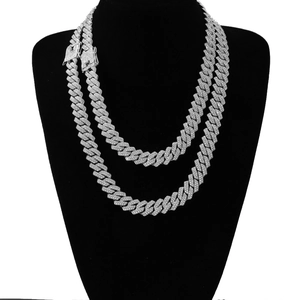 Macro shot of silver hip hop Cuban link chain necklace with sparkling rhinestones on black bust